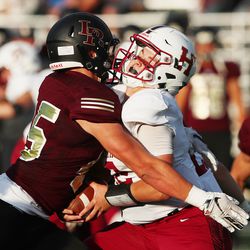 Herriman's Jaxon James is sacked by Lone Peak's Michael Daley as they open the 2018-19 football season at Lone Peak on Friday, Aug. 17, 2018. The game was delayed at the half for weather.
