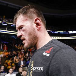 Stipe Miocic walks back to locker room a little worse for wear after his UFC 220 win.