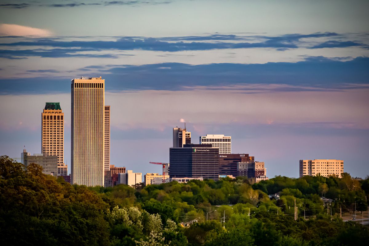 The Tulsa skyline with trees in the foreground.