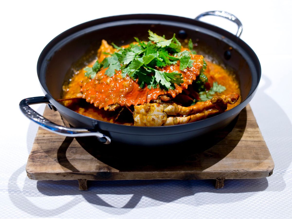 A large chilli crab, presented in a handled pot.