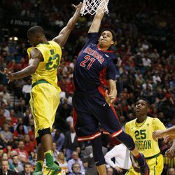 Arizona center Chance Comanche dunks over Oregon forward Elgin Cook, left, during the first half of an NCAA college basketball game in the semifinal round of the Pac-12 men's tournament Friday, March 11, 2016, in Las Vegas. 