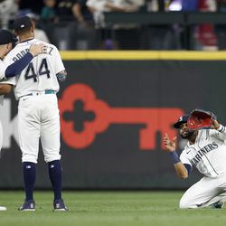OCTOBER 04: Jarred Kelenic #10 and Julio Rodriguez #44 of the Seattle Mariners pose for a pretend photo by Carlos Santana #41 after a 9-6 win against the Detroit Tigers at T-Mobile Park on October 04, 2022 in Seattle, Washington.
