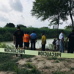 Authorities stand behind yellow warning tape along the Rio Grande bank where the bodies of Salvadoran migrant Oscar Alberto Martínez Ramírez and his nearly 2-year-old daughter Valeria were found, in Matamoros, Mexico, Monday, June 24, 2019, after they drowned trying to cross the river to Brownsville, Texas. Martinez's wife, Tania told Mexican authorities she watched her husband and child disappear in the strong current.
