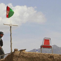An Afghan policeman stands guard on the roof of a house in the outskirts of Kabul, Saturday, April 6, 2013. NATO says a blast in Afghanistan has killed four coalition service members and two civilians working with the alliance. The blast from a roadside bomb occurred Saturday in southern Afghanistan.