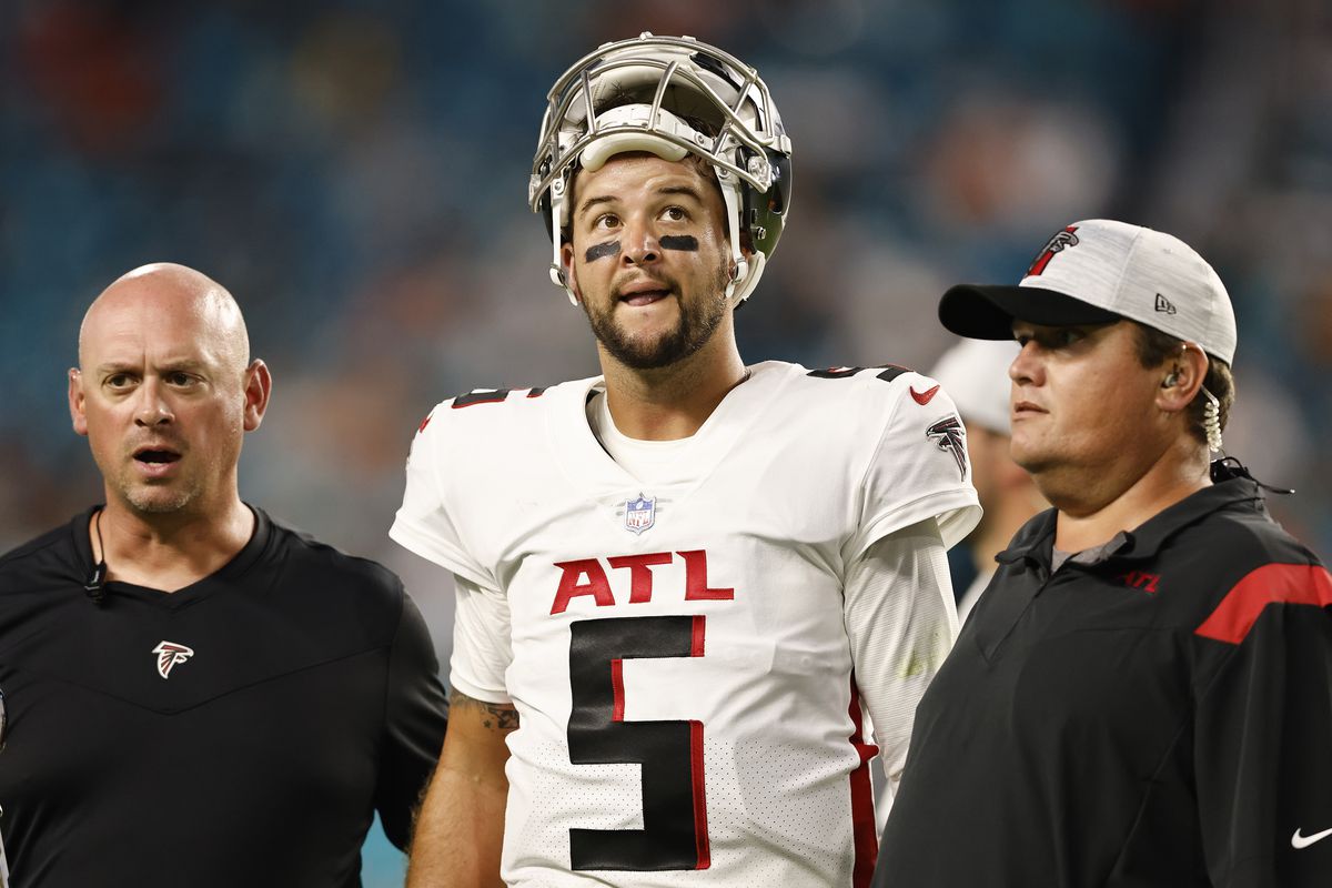MIAMI GARDENS, FLORIDA - AUGUST 21: AJ McCarron #5 of the Atlanta Falcons reacts as he is helped off the field by trainers after being injured during a preseason game against the Miami Dolphins at Hard Rock Stadium on August 21, 2021 in Miami Gardens, Florida.