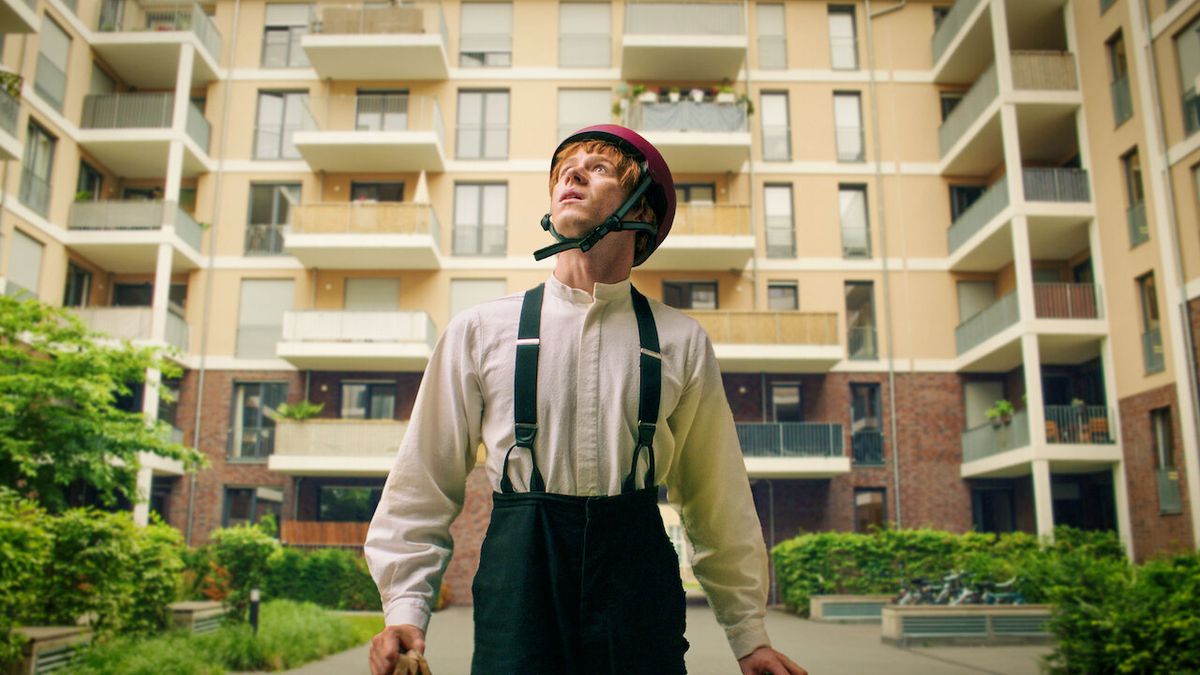 Jonas Holdenrieder como un joven amish con casco de bicicleta en Rumspringa (2022).