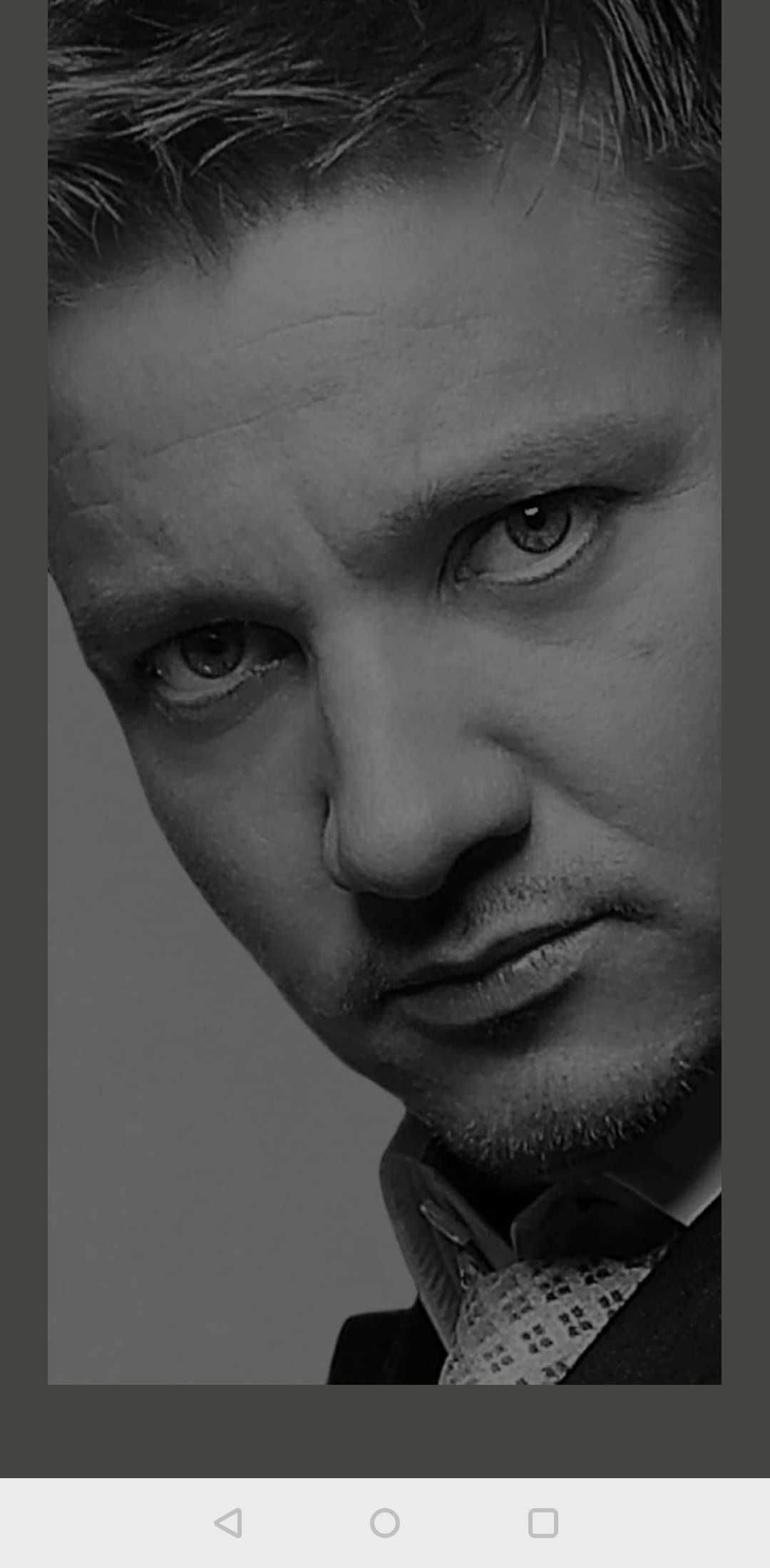 the loading screen of the Jeremy Renner app, featuring Jeremy Renner’s brooding face