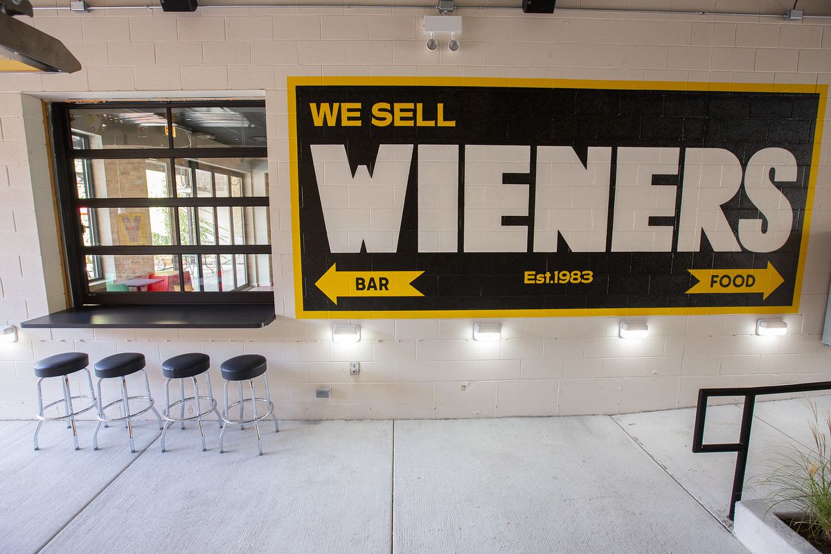 A brown sign that reads “We sells wieners.”