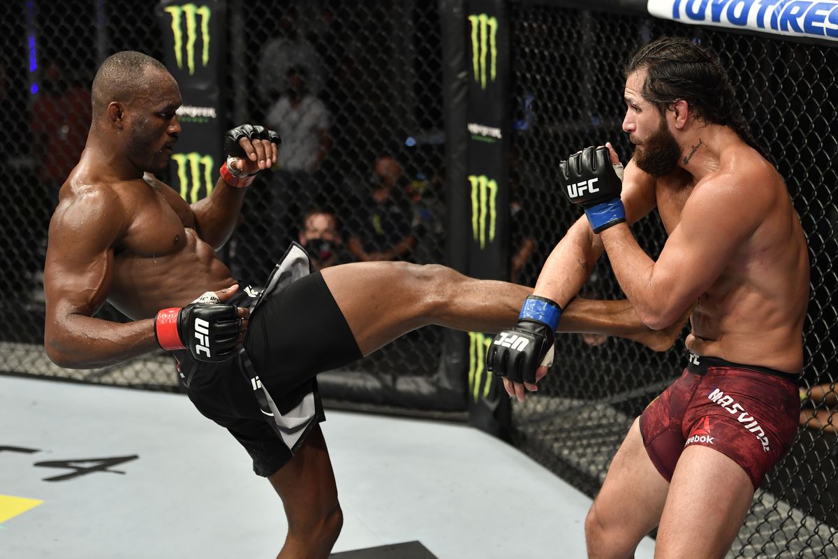 Kamaru Usman kicks Jorge Masvidal in their first fight at UFC 251.