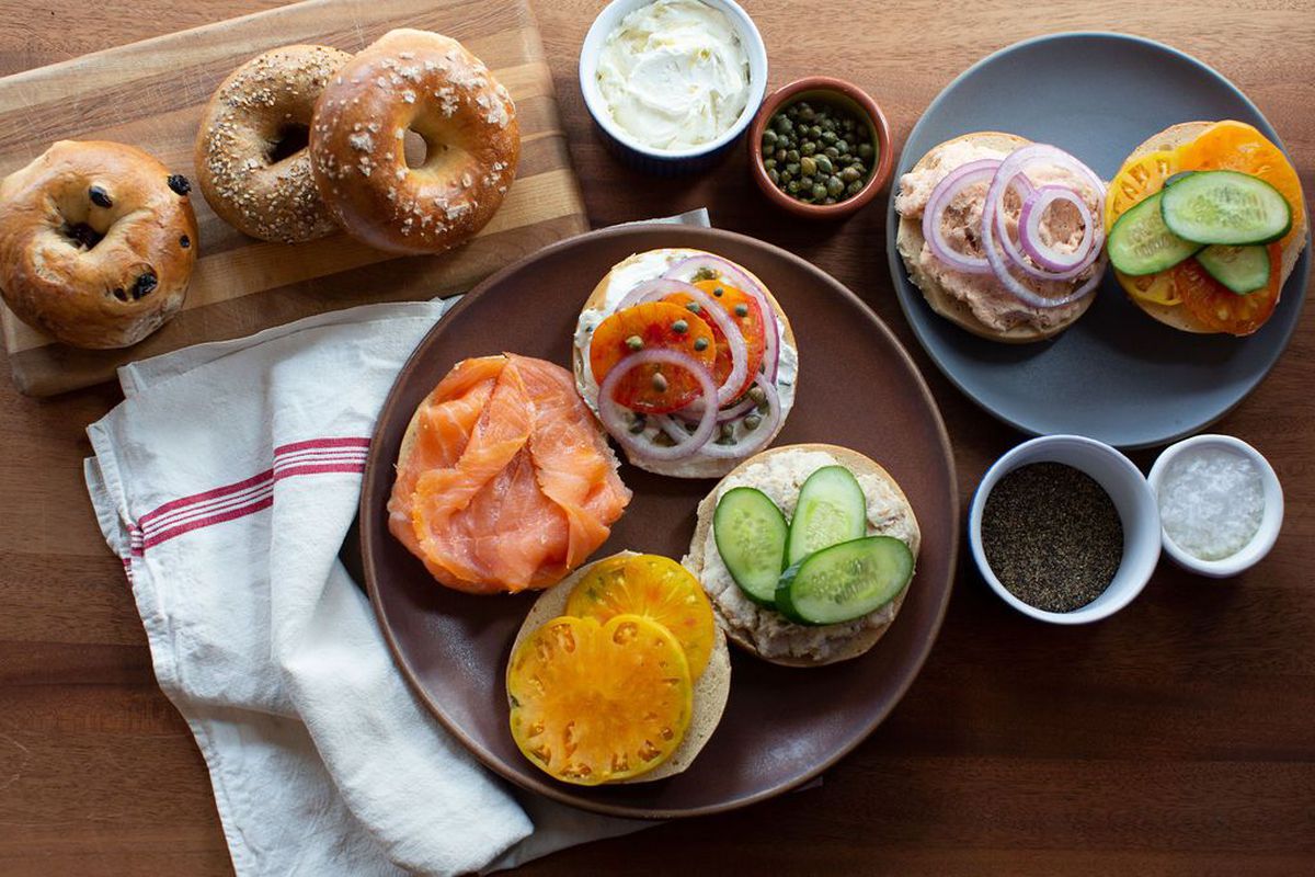 A spread of bagels, lox, and cream cheese spreads on a table from Boichik Bagels
