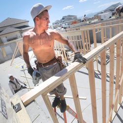 Rick Martinez of B&C construction places a board as workers frame up a home in the Bellevue subdivision of Ivory Homes Monday, June 17, 2013 in Draper.