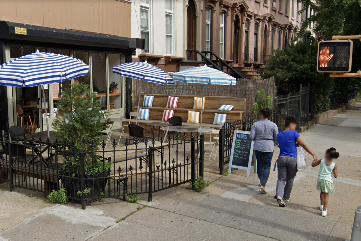 Two adults and a child can be seen in front of a Bed-Stuy cafe in a screenshot from Google Maps.
