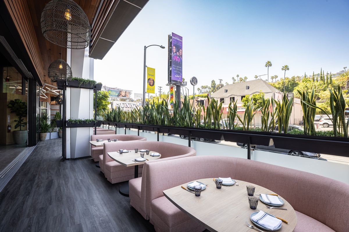 Millennial pink banquettes line the wraparound bar looking out to Sunset Boulevard at Charcoal Sunset.