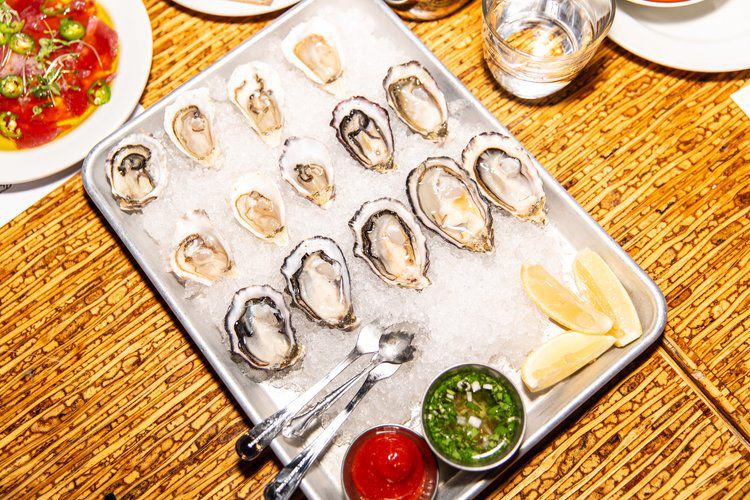 A tray of oysters with sauce and lemon slices at The Salty Pearl in Oakland.