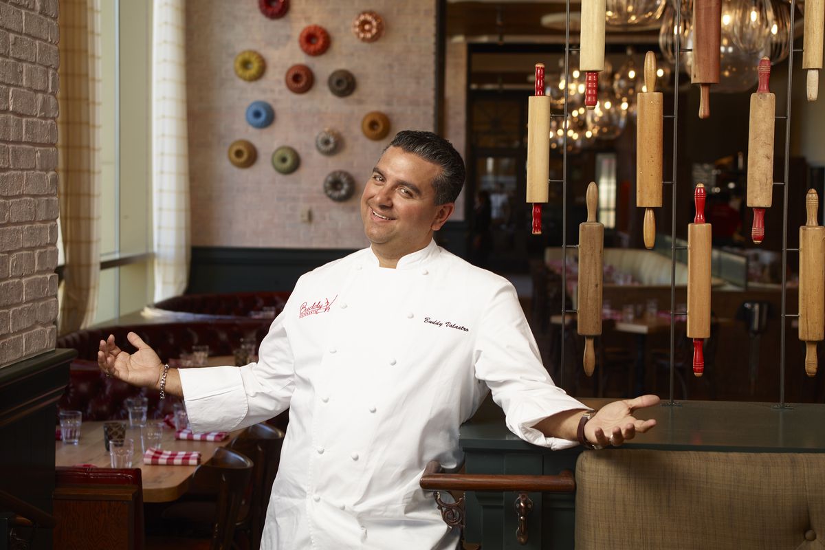 “Cake Boss” tv star Buddy Valastro stands in his signature pose, arms open to welcome guests to his restaurant.