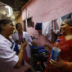 In this Tuesday, May 21, 2013 photo, Anjali S, a health work from Tata Memorial Hospital, briefs a group of women about cervical cancer during one of her regular visit to a slum in Mumbai, India. A simple vinegar test slashed cervical cancer death rates by one-third in a remarkable study of 150,000 women in the slums of India, where the disease is the top cancer killer of women. Experts called the outcome “amazing” and said this quick, cheap test could save tens of thousands of lives each year in developing countries by spotting early signs of cancer, allowing treatment before it’s too late. 