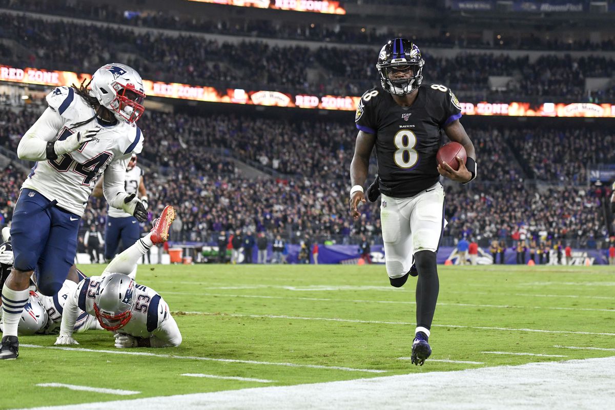 Baltimore Ravens quarterback Lamar Jackson runs with the ball during the third quarter against the New England Patriots at M&amp;T Bank Stadium.