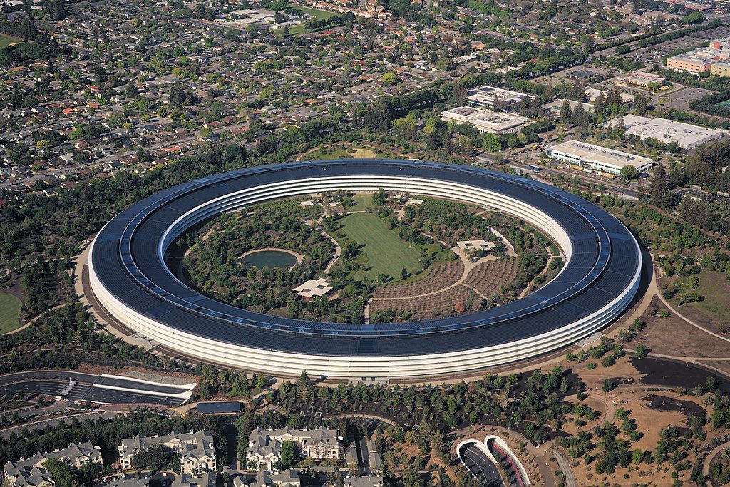 An aerial view of Cupertino, California. There is a round building structure surrounded by trees. 