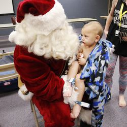 Axton Brown, a patient at Primary Children's Hospital, sits on Santa's lap at the Salt Lake hospital on Wednesday, Nov. 16, 2016. Santa spent time with children playing bingo and bringing them a present.