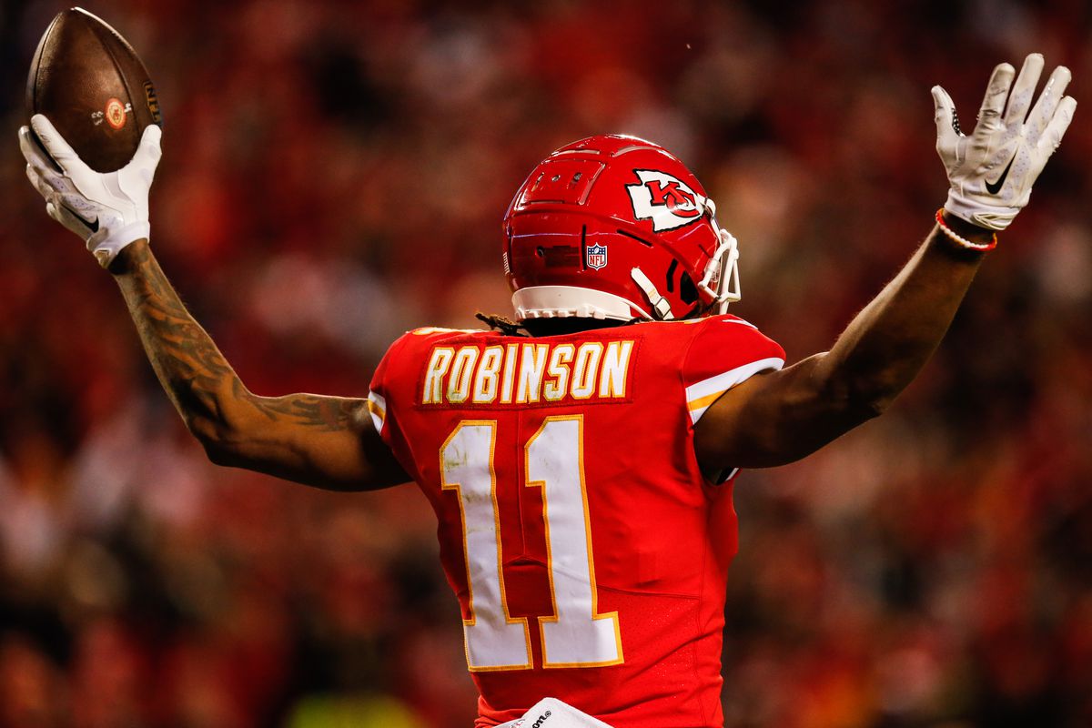 Demarcus Robinson #11 of the Kansas City Chiefs puts his arms up after catching the fiftieth touchdown pass of the season for his quarterback Patrick Mahomes #15 during the third quarter of the game against the Oakland Raiders at Arrowhead Stadium on December 30, 2018 in Kansas City, Missouri.