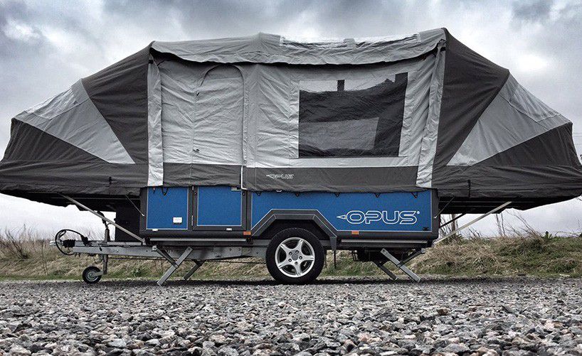 A trailer with a tent material top. The base is blue and the word Opus is on the side of the trailer.