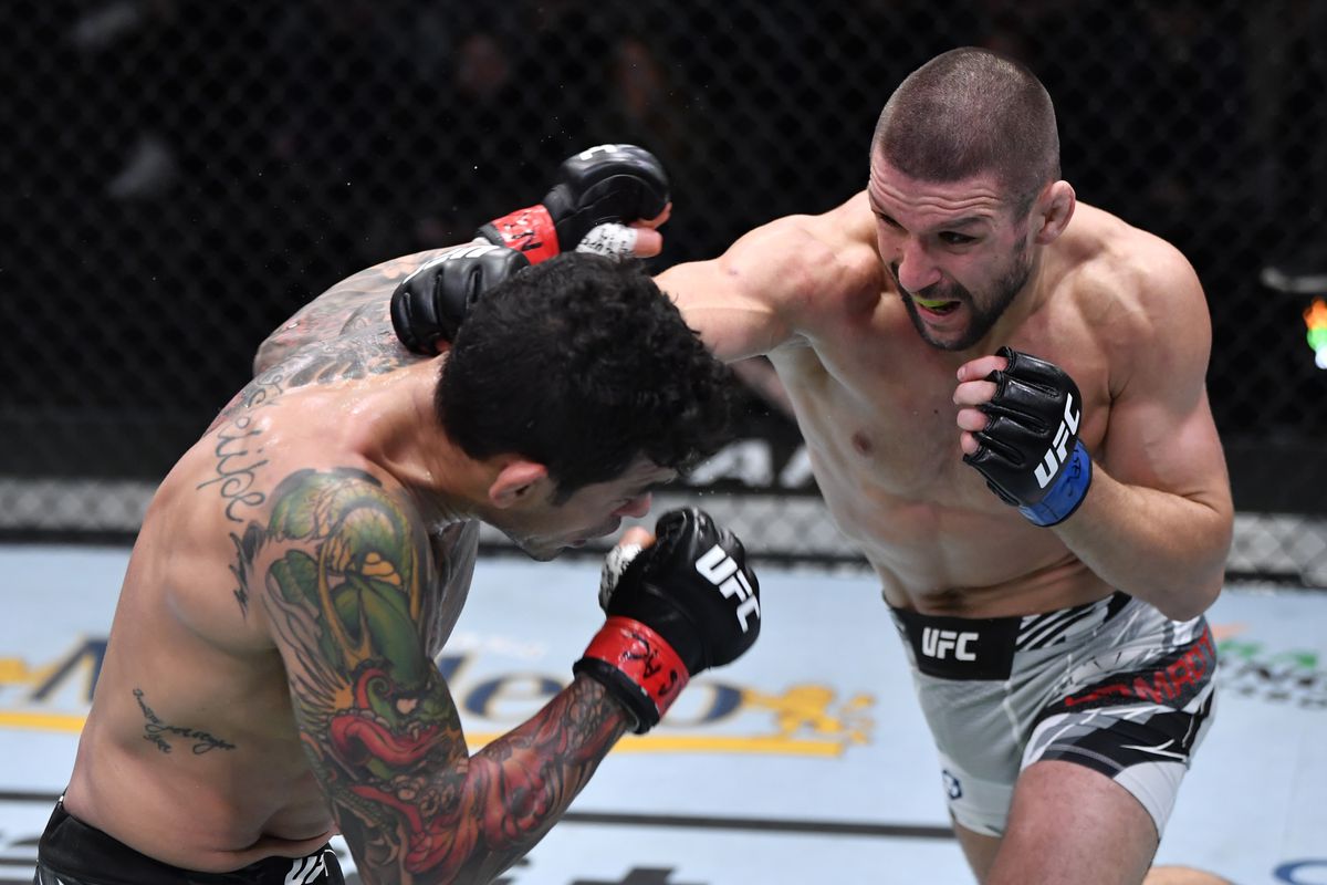 Mateusz Gamrot of Poland punches Diego Ferreira of Brazil in their lightweight fight during the UFC Fight Night event at UFC APEX on December 18, 2021 in Las Vegas, Nevada.