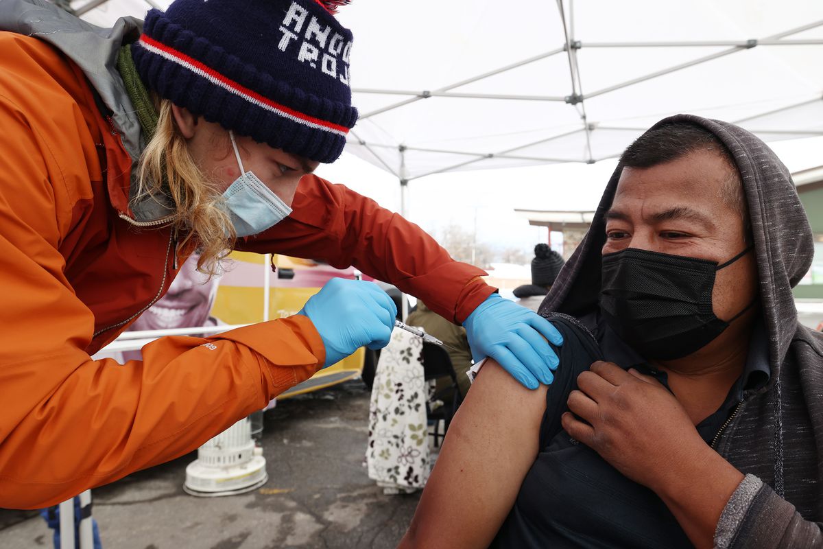 Tristin Torkelson, an EMT with Salt Lake County, gives Raymundo Altamirano a COVID-19 vaccination at a Salt Lake County Health Department mobile site at Tejeda’s Market.