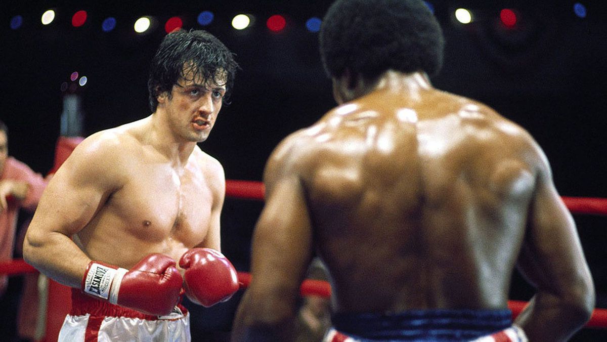 (L-R) Rocky Balboa (Sylvester Stallone) standing opposite of Apollo Creed (Carl Weathers) in Rocky