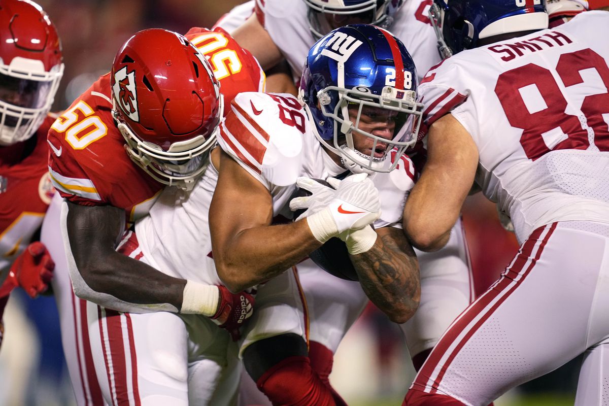 New York Giants running back Devontae Booker (28) is tackled by Kansas City Chiefs linebacker Willie Gay Jr. (50) during the first quarter at GEHA Field at Arrowhead Stadium.