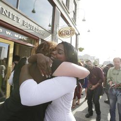Kitara Johnson, right, and Heidi Peterson hug after a demonstration for local NAACP chapter president Rachel Dolezal to step down Monday, June 15, 2015, in Spokane, Wash. Dolezal resigned as president of the NAACP's Spokane chapter Monday just days after her parents said she is a white woman posing as black. 