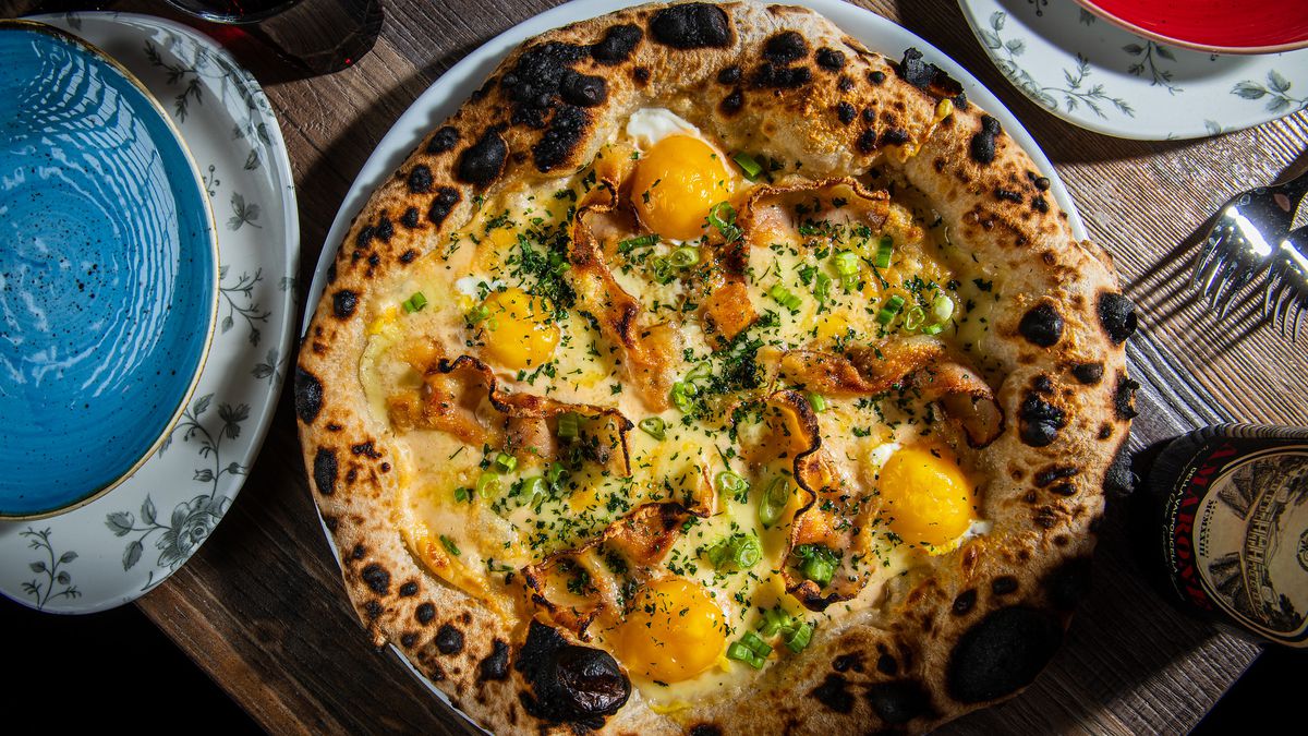 Lupo Pizzeria’s $20 carbonara pizza comes topped with pecorino cream, pork cheek, egg yolk, and a liberal sprinkling of black pepper