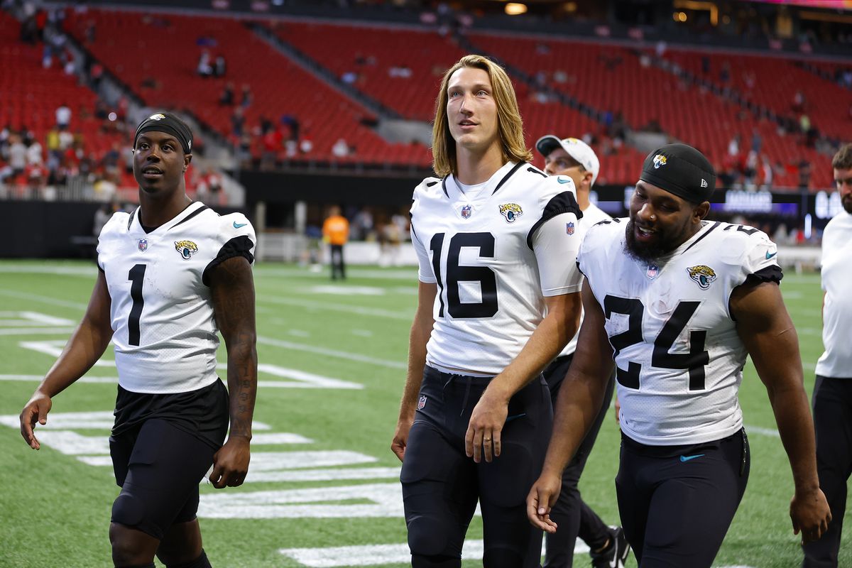 Travis Etienne Jr. #1, Trevor Lawrence #16 and Snoop Conner #24 of the Jacksonville Jaguars walk off the field following the preseason game against the Atlanta Falcons at Mercedes-Benz Stadium on August 27, 2022 in Atlanta, Georgia.