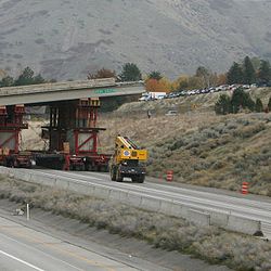 The machines are called "self propelled modular transporters," and look almost like flat-bed trailers stacked high with a hodge-podge of storage containers, barrels and chunks of wood that help support the heavy bridge segments.