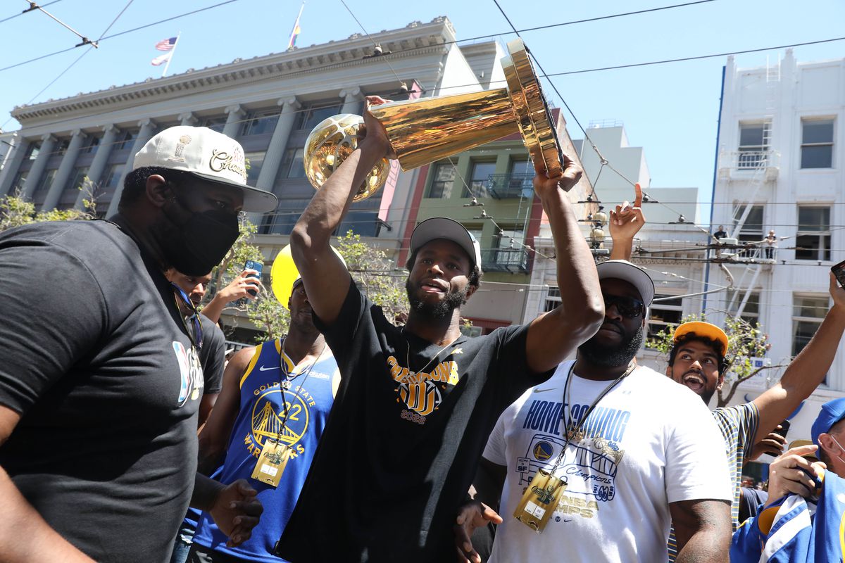 Andrew Wiggins holding a trophy over his head at the championship parade