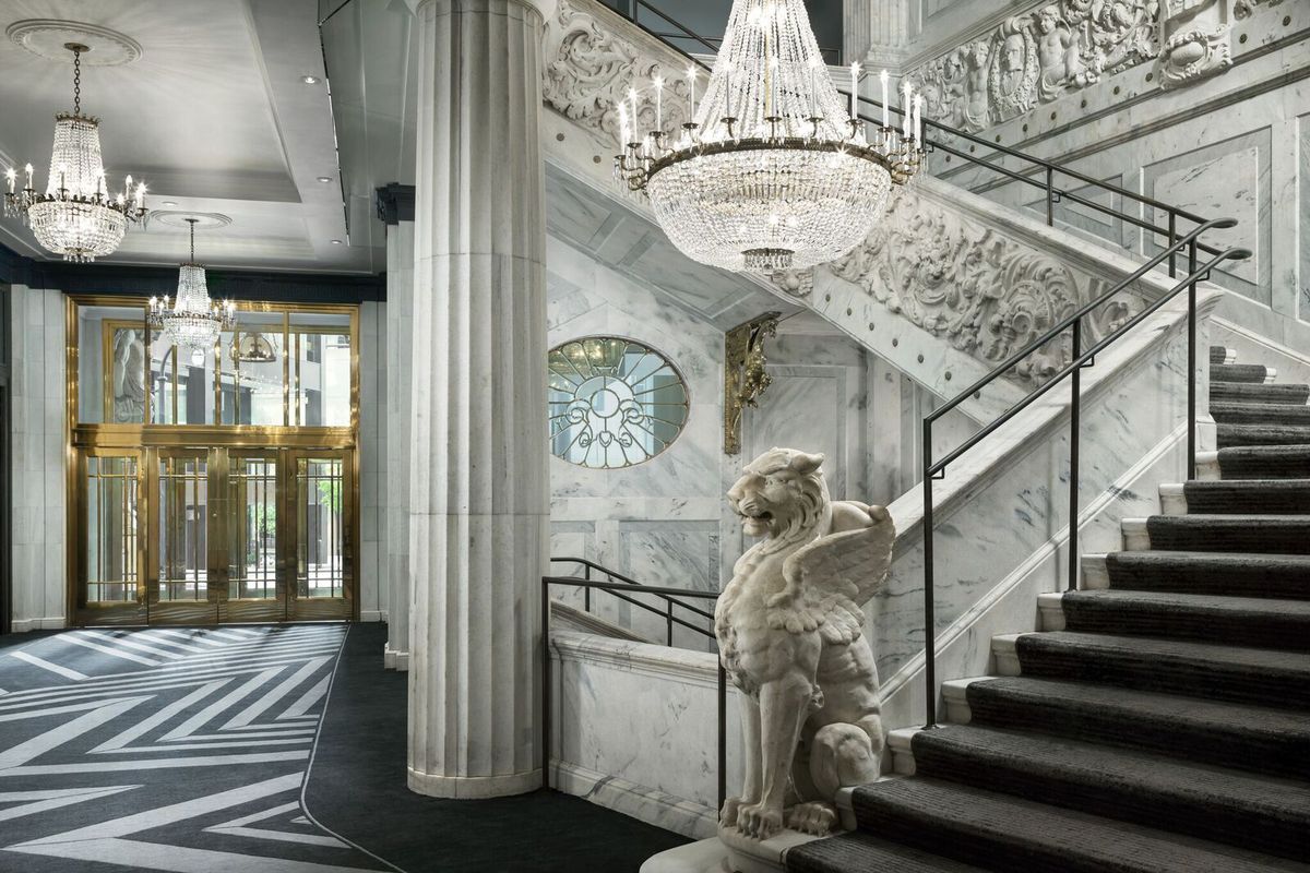 An opulent hotel lobby of marble and crystal.