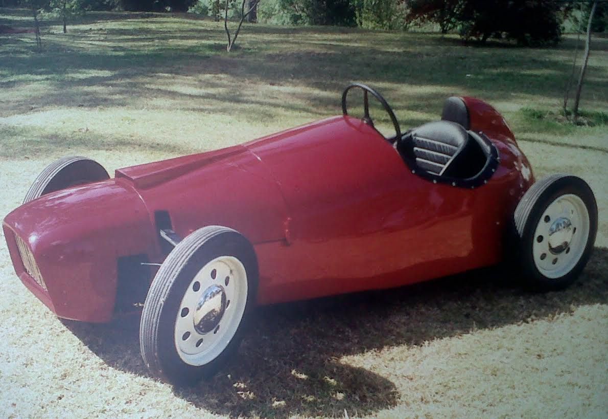 a single-seater, front-engine, 1950s style custom roadster painted in red