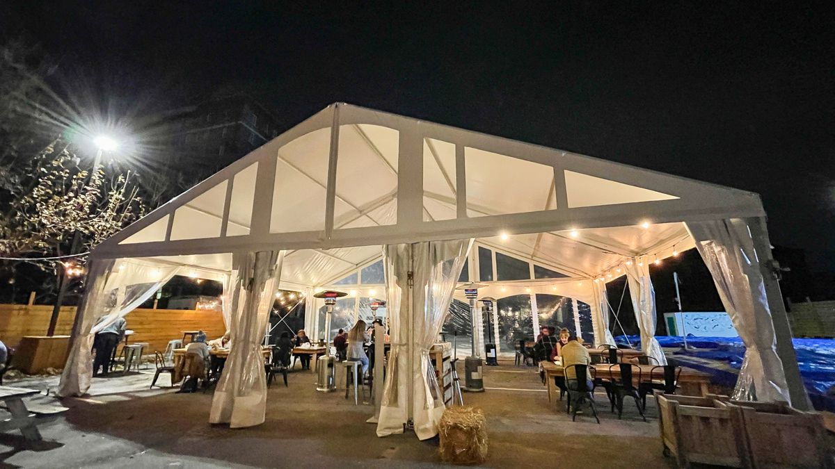 Detroit Shipping Company’s outdoor dining set up with a large white tent, heaters, and tables.