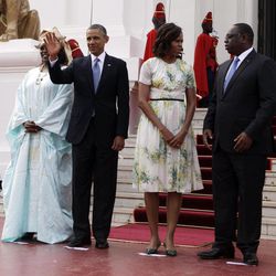 U.S. President Barack Obama waves as he poses for a picture alongside U.S. First Lady Michelle Obama, second right, Senegalese President Macky Sall, right, and Senegalese First Lady Mariame Faye Sall at the presidential palace in Dakar, Senegal, Thursday, June 27, 2013. President Obama arrived in Senegal Wednesday night to kick off a weeklong trip to Africa, a three-country visit aimed at overcoming disappointment on the continent over the first black U.S. president's lack of personal engagement during his first term. 