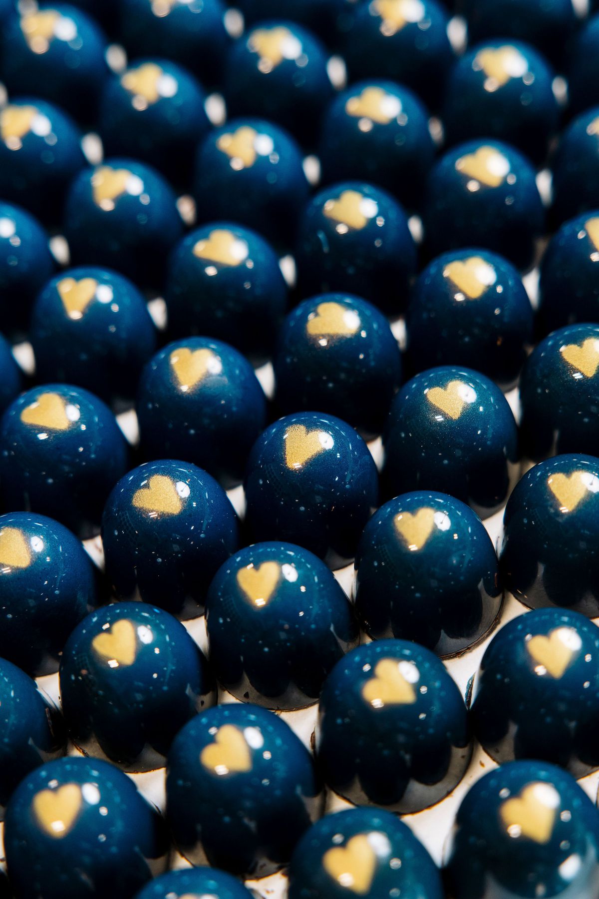 Rows of blue bonbons with a yellow heart in the middle.