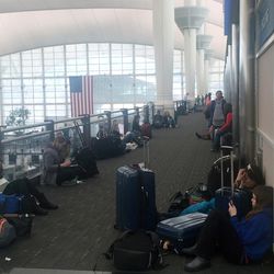 In this photo provided by Glynnis O'Connell, passengers sit with their baggage in the main terminal of Denver International Airport on Wednesday, March 23, 2016, as a spring storm, packing high winds and wet, heavy snow, forced officials to shut down the airport. The storm has wreaked havoc for travelers in the Intermountain West, closing roads and even schools as the storm rumbles through on to the plains. (Glynnis O'Connell via AP) MANDATORY CREDIT