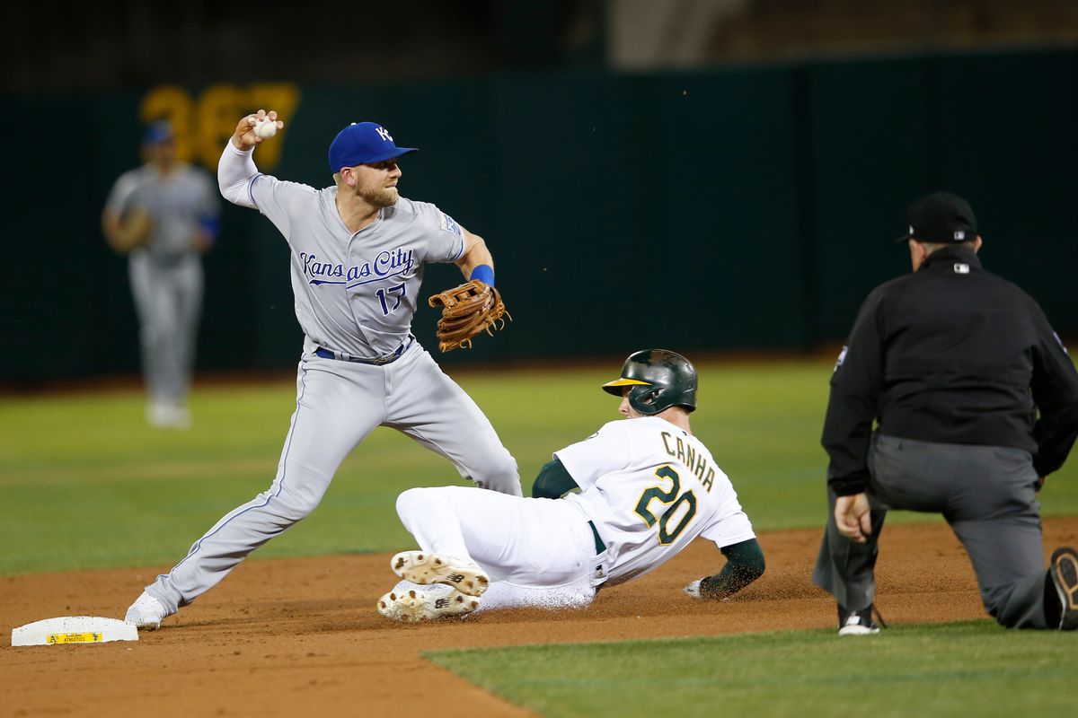 Hunter Dozier #17 of the Kansas City Royals forces Mark Canha #20 of the Oakland Athletics out at second during the game at the Oakland-Alameda County Coliseum on September 17, 2019 in Oakland, California. The Athletics defeated the Royals 2-1.