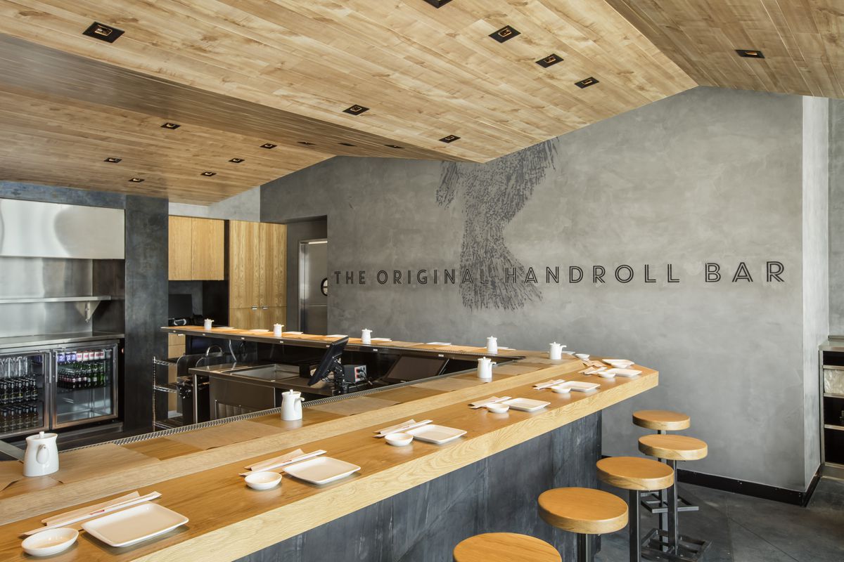 Interior of Kazunori restaurant with clean concrete walls, wood-paneled ceilings, and a wooden sushi counter.