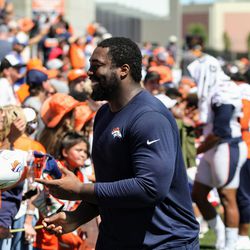 Broncos NT Shelby Harris tosses a freshly autographed ball back to a fan.