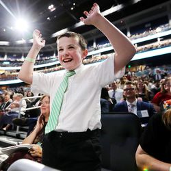 Ethan Meyers waves his arms and his mom, Sarah Meyers, laughs as they listen to President Russell M. Nelson speak at a devotional at the Amway Center in Orlando, Florida, on Sunday, June 9, 2019.