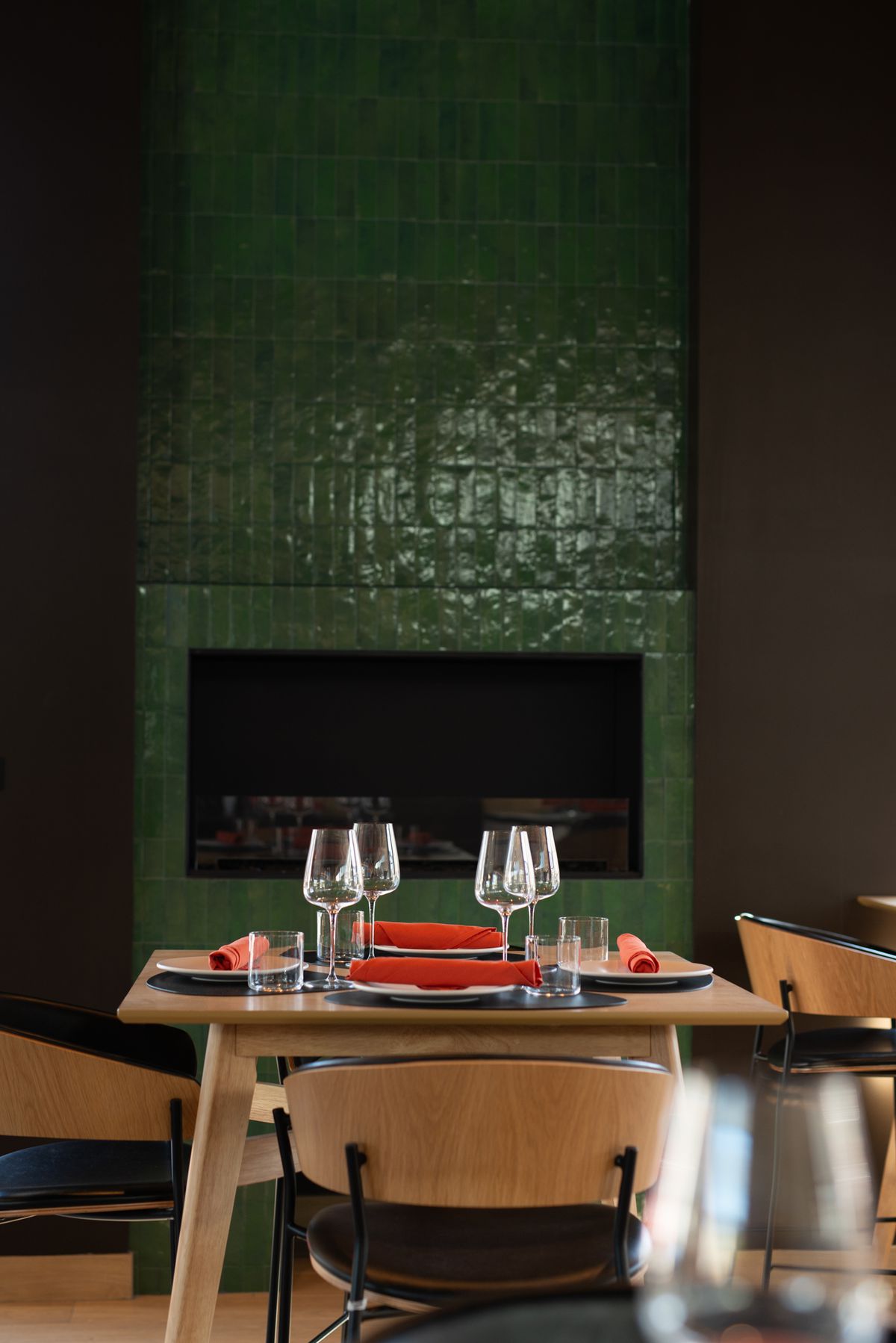 A green tiled fireplace in the dining room at L’antica in Long Beach.