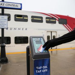 A woman uses an electronic card reader before boarding a FrontRunner train at the Utah Transit Authority's Salt Lake Central Station on Tuesday, Dec. 6, 2016.