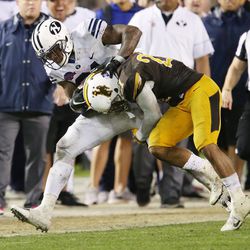Brigham Young Cougars running back Jamaal Williams (21) runs over Wyoming Cowboys cornerback Sidney Washington Jr. (22) during the Poinsettia Bowl in San Diego on Wednesday, Dec. 21, 2016. BYU won 24-21.