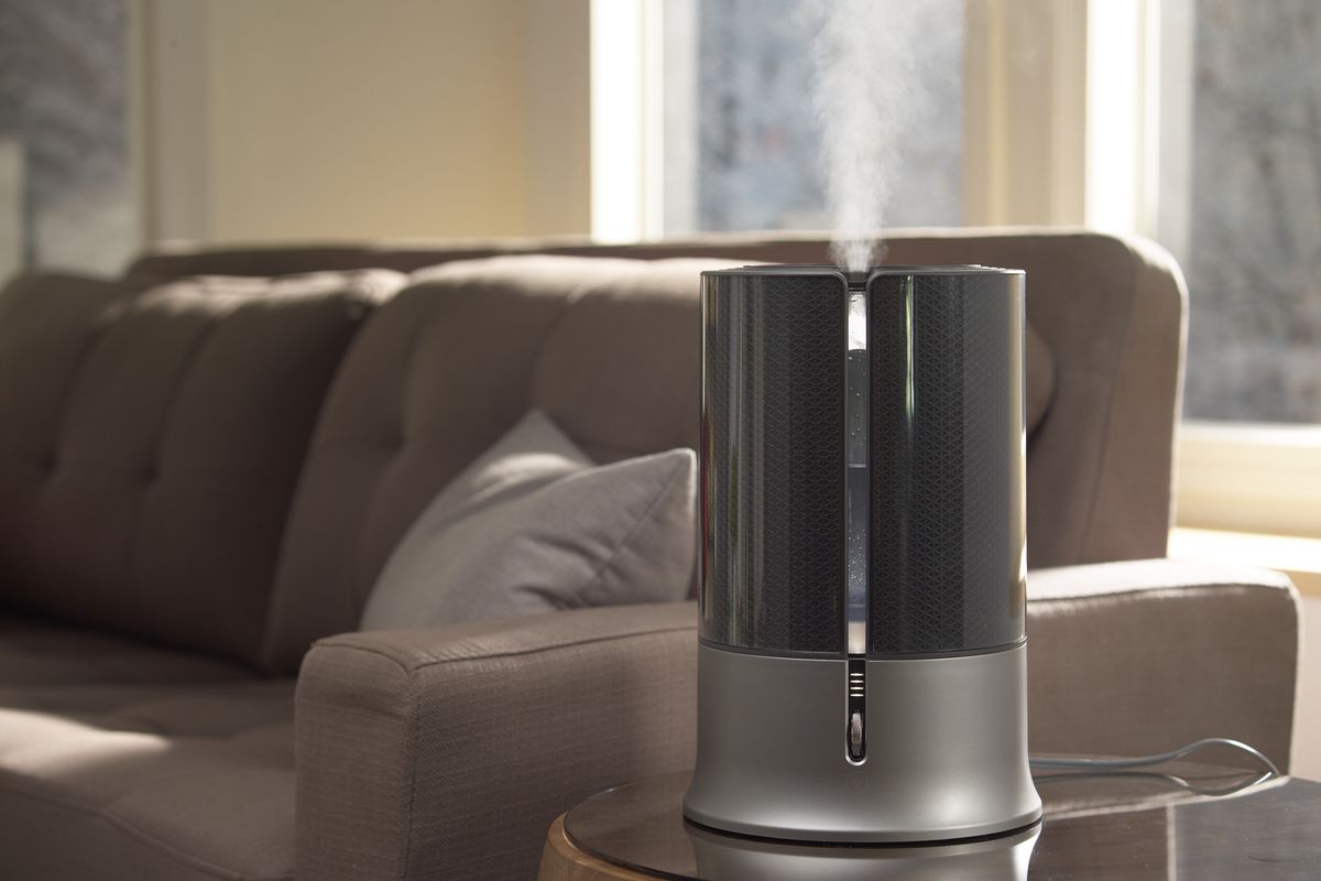 humidifier sitting on end table releasing cool mist in a living room
