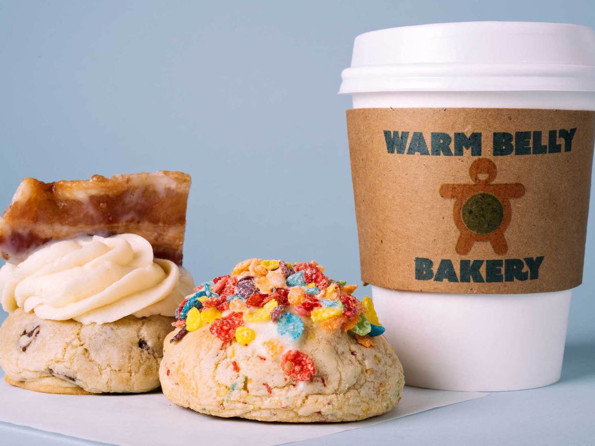 Two cookies and a coffee cup from Warm Belly with lots of colorful toppings.