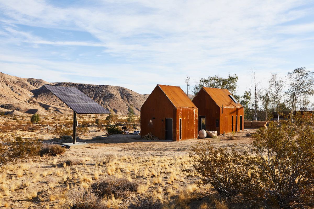 Two steel cabins in desert with solar power tree 